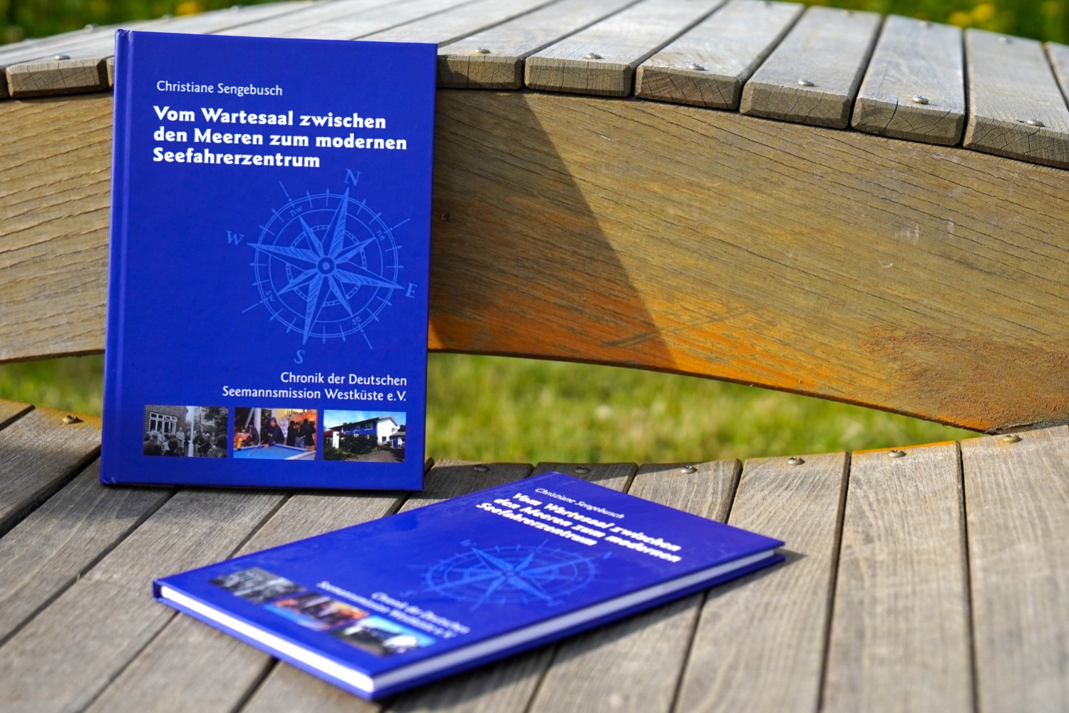 Two copies of the chronicle of the Seamen’s Mission Brunsbüttel lie on a wooden bench
