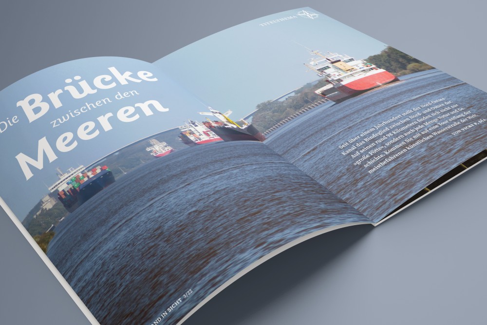 The magazine “LAND IN SICHT” is lying open. A picture of ships can be seen.